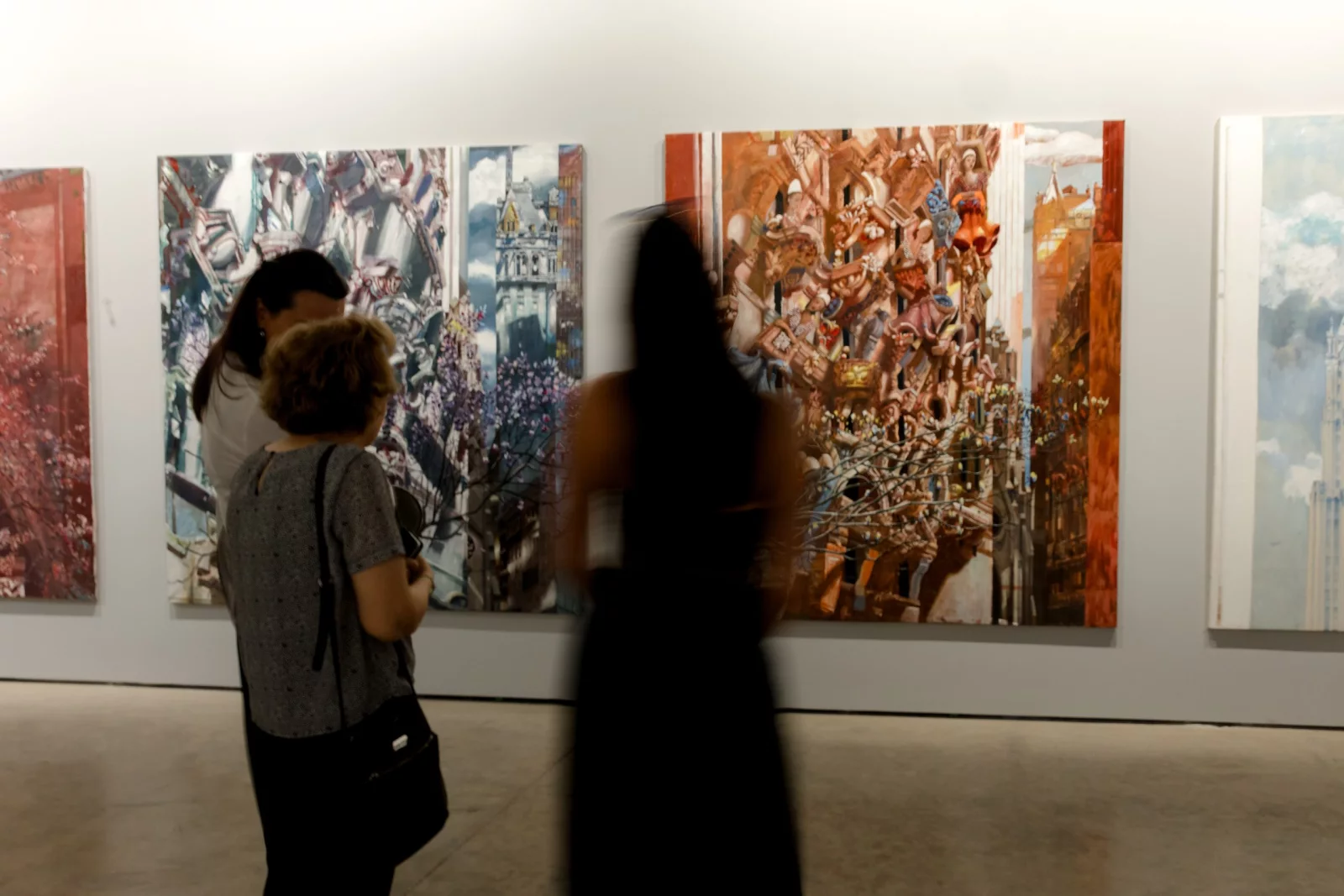 Visitors with paintings at the Wanderlust exhibition at GOCAT